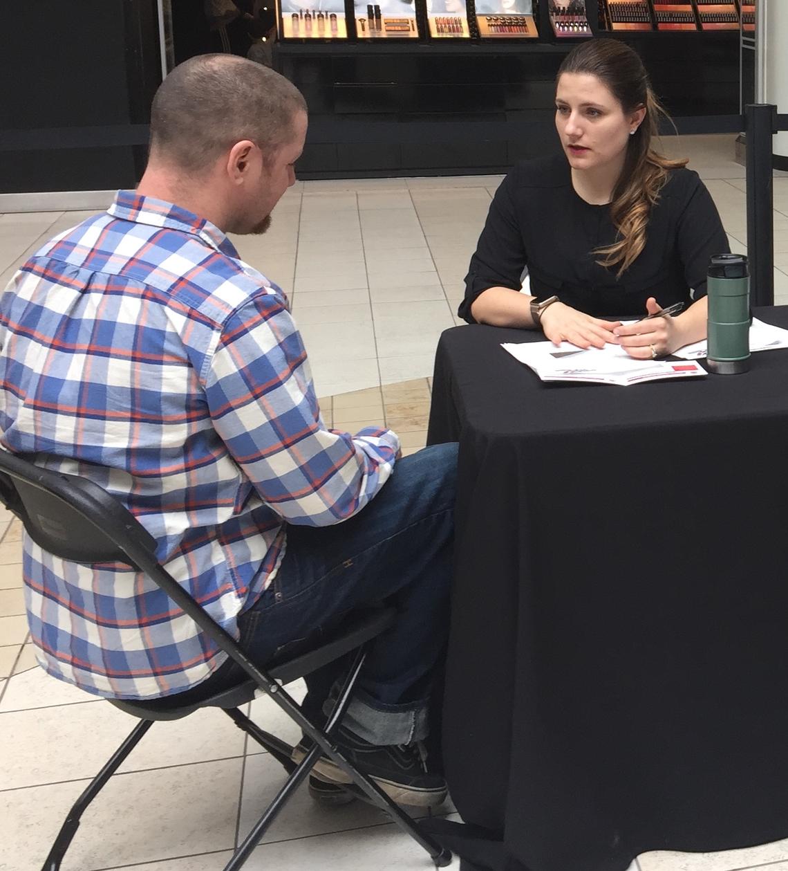 A volunteer speaks with a mall-goer at the fourth annual Flames Health Training Camp.