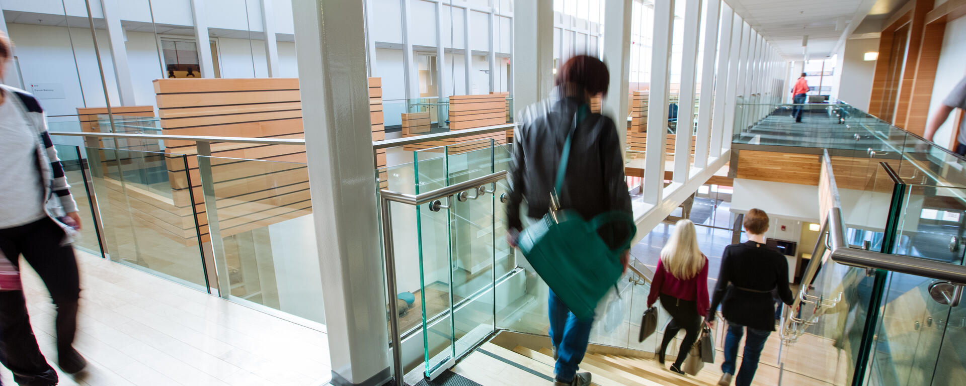 People walking through the Taylor Institute building and down the stairs.