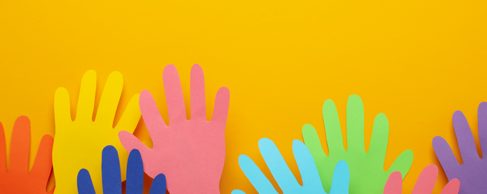 Felt, differently coloured hands are raised in front of an orange background