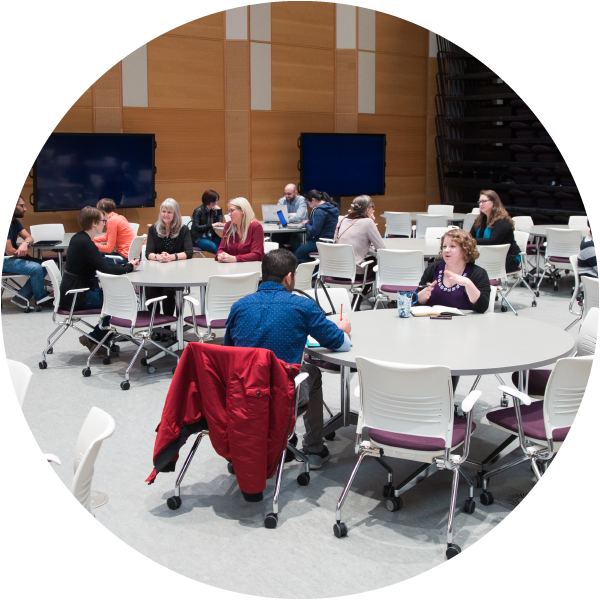 People sitting at tables in the Taylor Institute forum