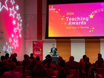 An event host speaks to a full room of people