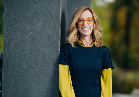 A photo of Dr. Cari Dinn leaning against a wall outside