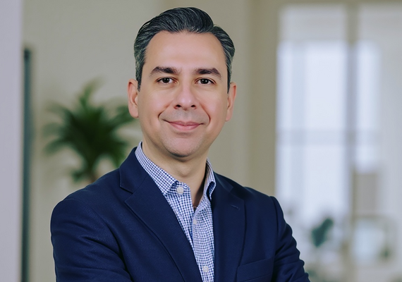 An AI created photo of Soroush Sabbaghan depicting a man with light skin, short grey hair and wearing a blue blazer and collared shirt.