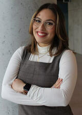 Student Jasmine El-Hacha stands smiling with her arms folded