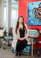 Chantal Large sits on a chair facing the camera.