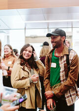 Smiling students at the PURE event converse in a group