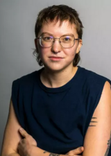 A student looks toward the camera on a gray portrait background