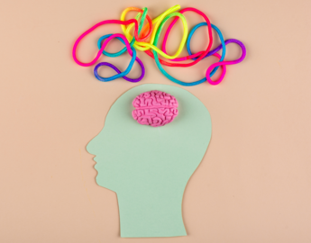 A felt image of a person's head sits below a colourful assortment of yarn depicting their many thoughts